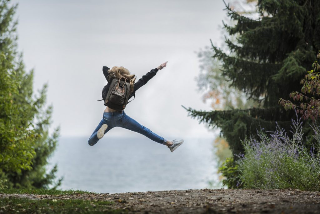 Girl hiking outside jumping